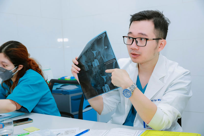 bác sĩ vương vũ việt hà đang đọc kết quả phim cho bệnh nhân